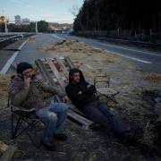 Farmers sit on a highway after spending the night at a barricade in Aix-en-Provence, southern France (AP Photo/Daniel Cole)