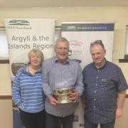 Long-serving Mid Argyll member John Semple (centre) has been awarded the prestigious Argyll and the Islands Stalwart Award for 2024 by NFU Scotland.