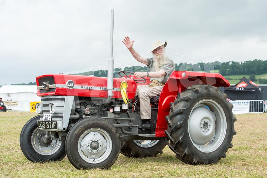 Laurence Blair Oliphant, giving big waves as he parades his Massey Ferguson 135  round the main ring at Alyth show. Ref: RH17617357