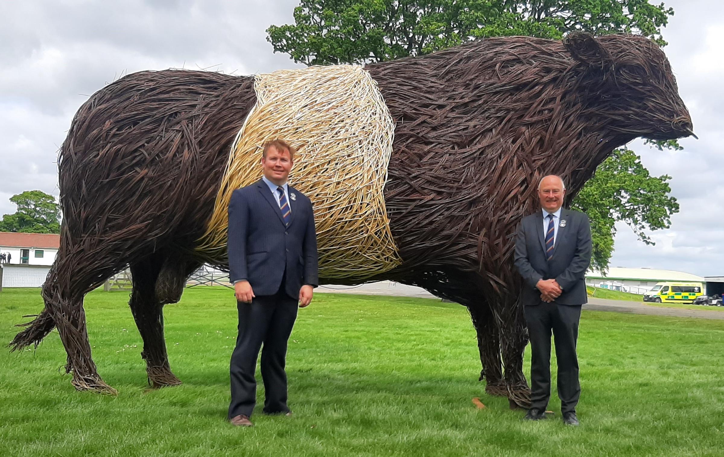 Alan Laidlaw and Bill Gray with a feature of the Showcase outside the new Members Pavilion, a giant Wickerman-style Belted Galloway bull – a reflection on the fact that this was Dumfries and Galloways year of presidency of RHASS
