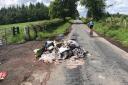 Builders' rubble dumped on the road in front of a field entrace in Lanarkshire