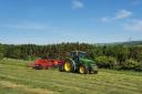 The sun shining in the summer months with a John Deere and Lely Hibiscus 915d rake
