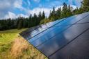 Photovoltaic panels mounted in a mountain meadow near the forest. Renewable energy source