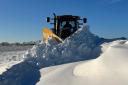 Stuart Gauld, skillfully operates a tractor to clear the snow-covered roads.