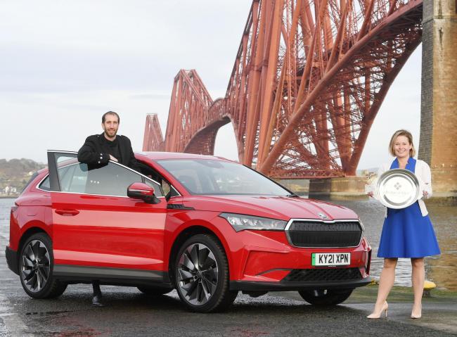 Scottish Car of the Year 2021 is the Skoda Enyaq, pictured at the Forth Rail Bridge, with Association of Scottish Motoring Writers president, Jack McKeown, with Kirsten Stagg, head of marketing atSkoda UK, receiving the Scottish Car of the Year title
