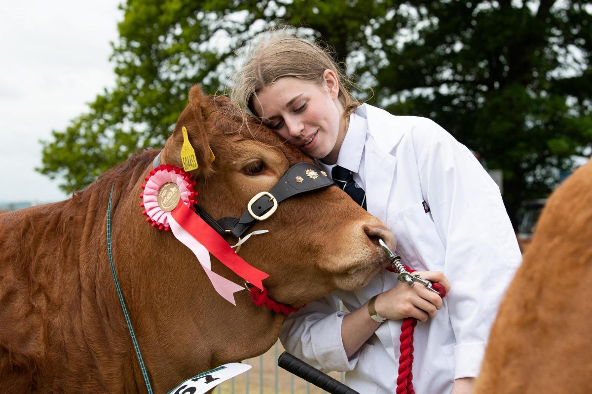 Cuddles from Beth Thomson as Beath Shelby stood champion in the Limousin section Ref:RH210522347  Rob Haining / The Scottish Farmer...