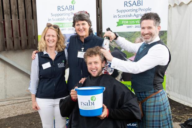 The Scottish Farmer: Kilted Barber Campbell Ewen takes a bit off the top for Cammy Wilson, from RSABI CEO,Carol McLaren and development officer Margo Wills Ref:RH010622113 Rob Haining / The Scottish Farmer...