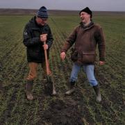 UKRAINE has long been a huge exporter of proteins and wheat, with strong links to the UK. Pictured here, in happier times, Ukraine-based Scots agronomist Dr Keith Dawson (left) shares some fun with one of his local counterparts when checking on the soil