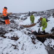 Coir logs are installed to manage water flow pathways in areas of bare peat
