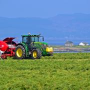 REYNOLDS TEAM baling at Wee Kilmory Farm, Isle of Bute, for Ian Dickson, with St Ninians Bay in the background