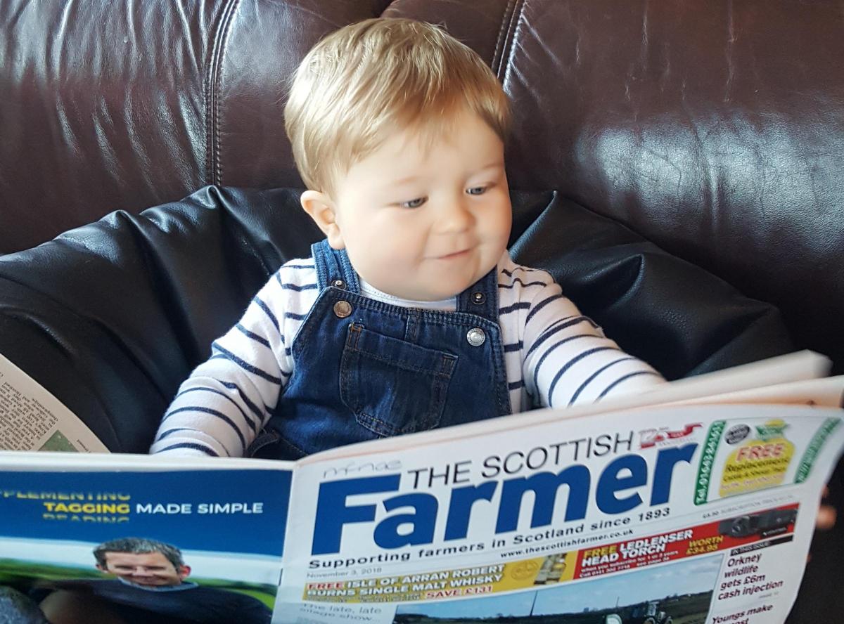 Little Aaron Hamilton-Black, 19 months-old, is having breakfast at granny and grandpa Hamilton's farm, Kirknewton, West Lothian, while he browses his favourite paper